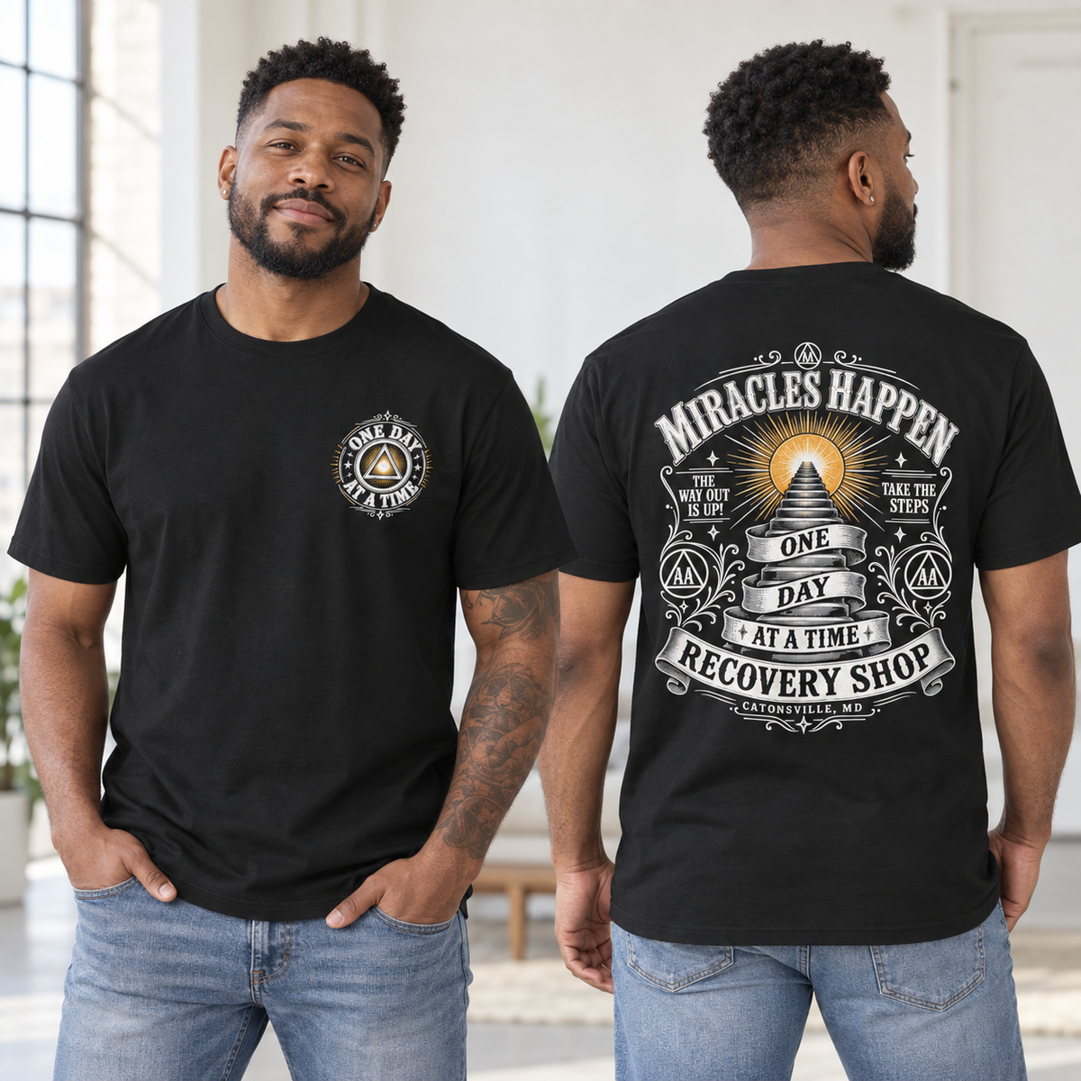 A man modeling a black graphic T-shirt, shown from both the front and back. The front features a small circular chest graphic reading 'ONE DAY AT A TIME' with a pyramid and triangle.
